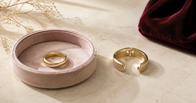 A plain ring in a padded dish beside an open adaptive ring on a cream surface.
